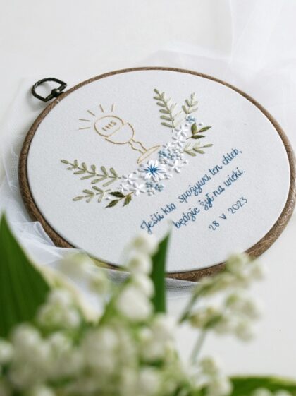 Haftowana pamiątka Pierwszej Komunii Świętej z cytatem, motyw kielicha z hostią i kwiatami