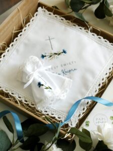 Biała szatka na chrzest z profitką i świecą. Haftowane ręcznie motywem chabrów.