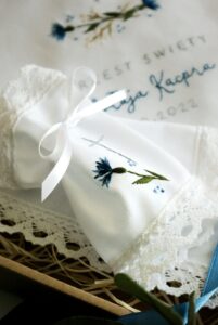 Haftowana profitka do swiecy z koronką i motywem chabrów.