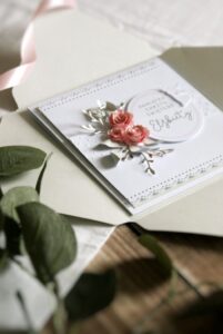 Kartka okolicznościowa z różowymi rożyczkami z papieru i aniołkiem oraz personalizowanym napisem