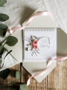 Kartka okolicznościowa z różowymi rożyczkami z papieru i aniołkiem oraz personalizowanym napisem