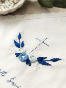 kwadratowa szatka do Chrztu Świętego z niebieskim haftem i koronką