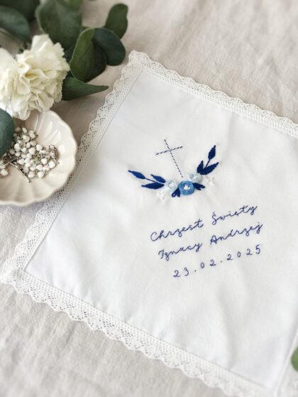kwadratowa szatka do Chrztu Świętego z niebieskim haftem krzyża z kwiatami i koronką