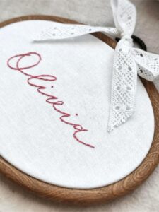 Owalny minimalistyczny tamborek z haftowanym imieniem i koronką