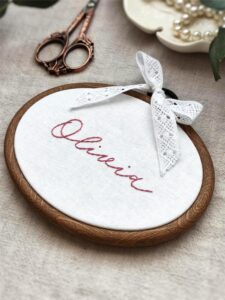Owalny minimalistyczny tamborek z haftowanym imieniem i koronką