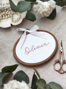 Owalny minimalistyczny tamborek z haftowanym imieniem i koronką